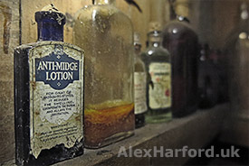 Old anti-midge lotion on shelf in abandoned house