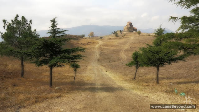Path to Jvari Church between foreground trees